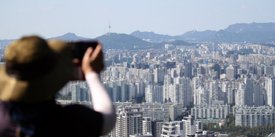 서울 아파트값과 전셋값이 좀처럼 안정세로 접어들지 못하고 있다. 한 시민이 아파트 밀집 지역을 촬영하고 있다. <연합뉴스>